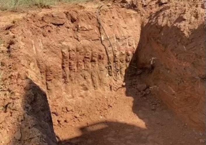 An excavated pit in red clay, dug and graded ready for a tank set