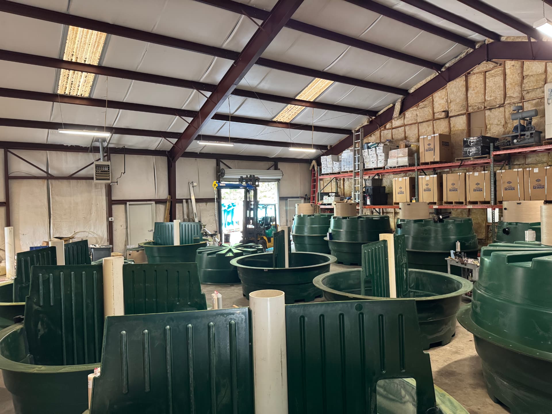 EMS warehouse stocked with green Orenco treatment systems ready for delivery and installation.
