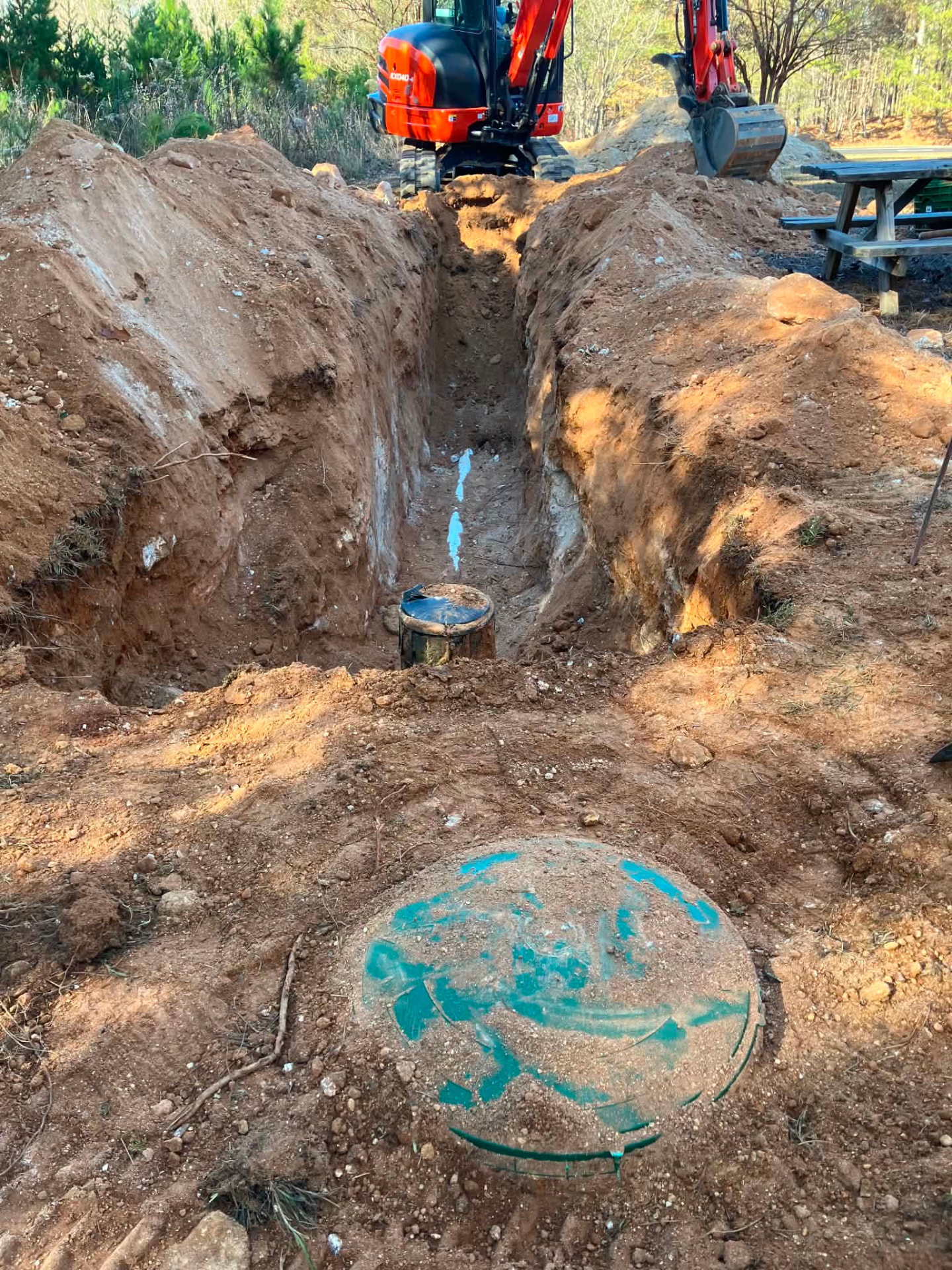 Excavators digging a trench for a wastewater system installation.
